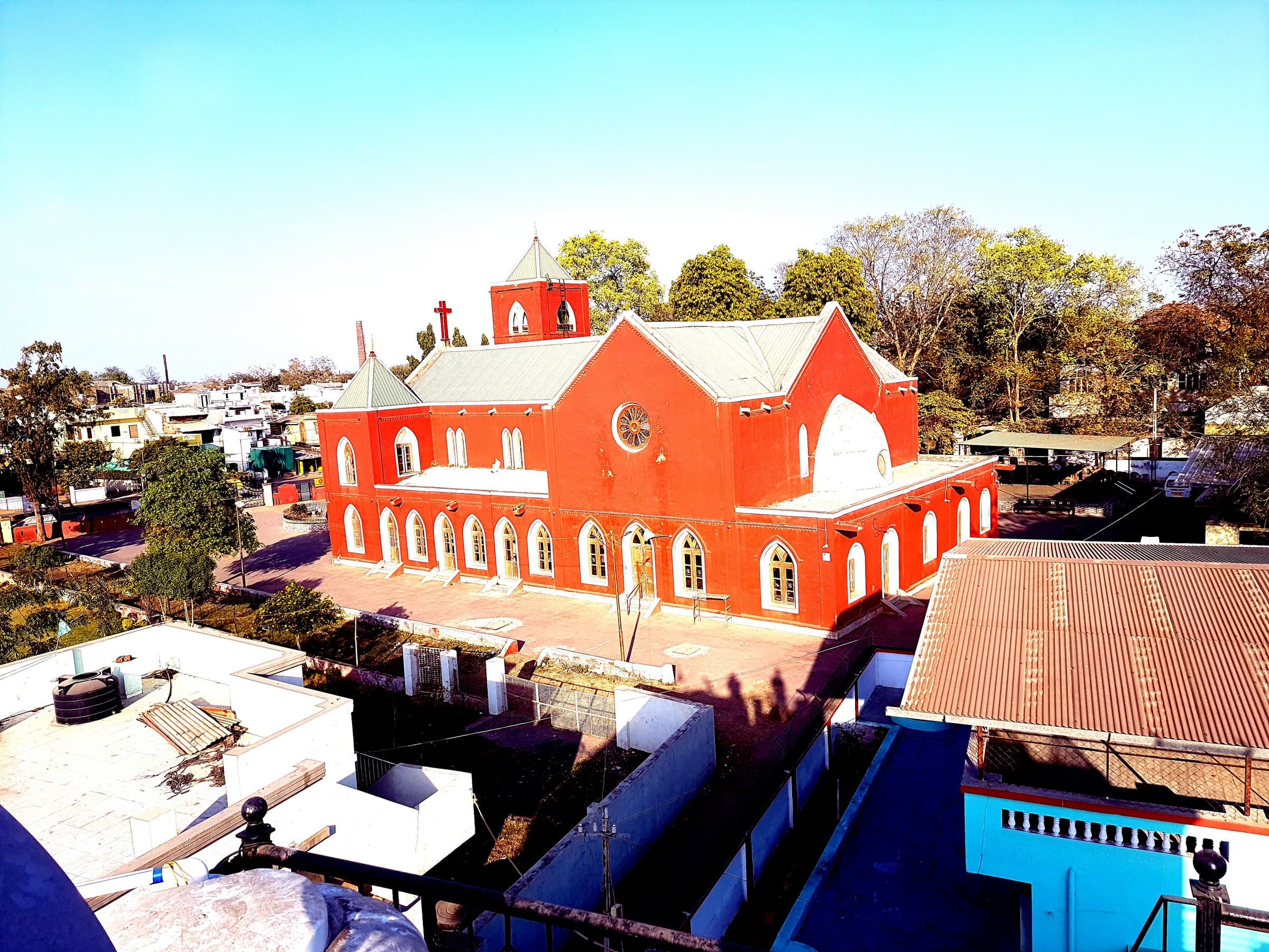 Methodist Church Nadiad seen from above, its green pitched roof and bell tower rising over the rooftops of Nadiad.
